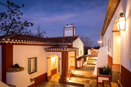 - une vue sur une maison avec une terrasse couverte la nuit dans l'établissement Hotel Rural Monte da Provença, à Elvas