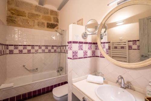 a bathroom with a sink and a tub and a mirror at YIT La Casona del Arco in Baeza