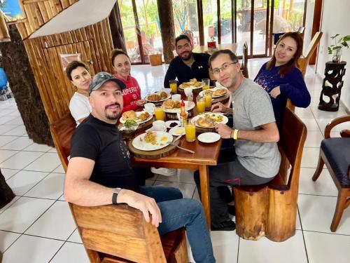 a group of people sitting around a table eating food at Natura Gardens Galápagos in Bellavista
