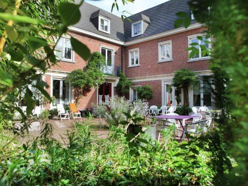 ein großes Backsteinhaus mit einem Tisch und Stühlen in der Unterkunft Comfortable Mansion in Doomkerke near Forest in Ruiselede