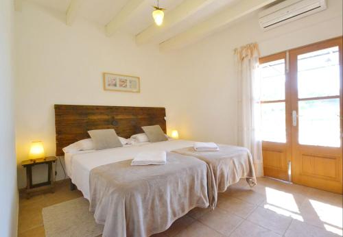 een slaapkamer met 2 bedden met witte lakens en een deur bij Sa Volta in Selva