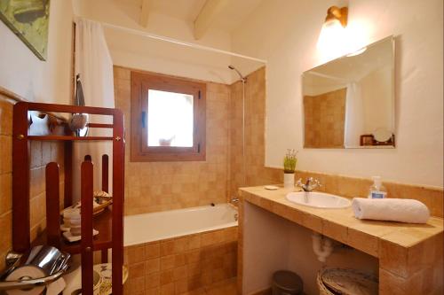 een badkamer met een bad, een wastafel en een bad tubermottermott bij Sa Volta in Selva