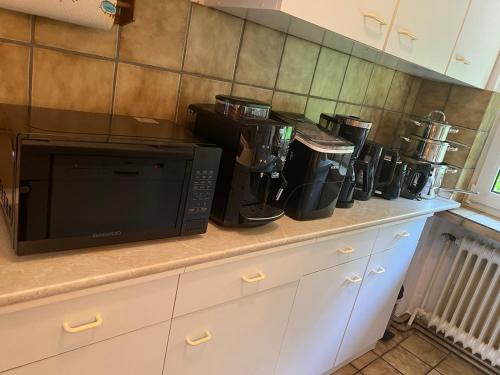 a kitchen counter with a microwave and coffee cups on it at Ferienwohnung E in Soltau