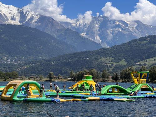 a group of inflatable parks on a lake with mountains at Chalet Aventure B&B Les Gets in Les Gets
