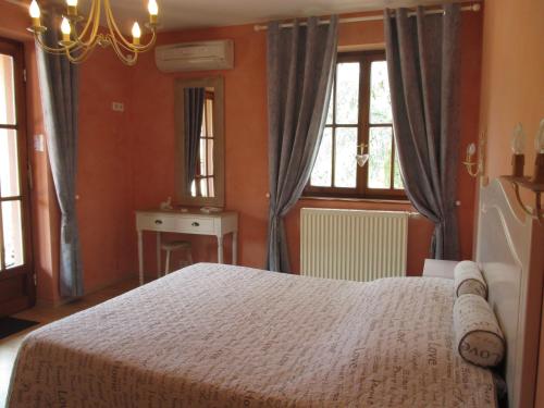 ein Schlafzimmer mit einem Bett und zwei Fenstern in der Unterkunft Gite Chez Jean in Saint-Hippolyte