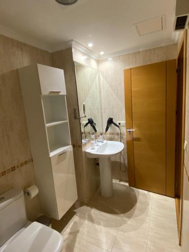 ein Bad mit einem Waschbecken und einem WC in der Unterkunft Apartamento con vistas al mar, piscina y parking in Sanxenxo