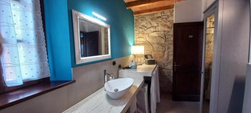 a bathroom with a white sink and a mirror at Il Bordone del Pellegrino in Terenzo