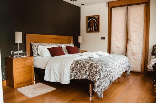 a bedroom with a large bed and a wooden floor at Baiolei in Azpeitia