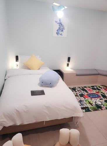 a bedroom with a large white bed and a rug at Geoje Mongdol Beach H Avenue Hotel in Geoje 