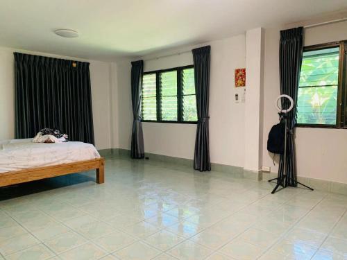 1 dormitorio con cama, ventanas y suelo de baldosa. en 中泰一家亲 en Chiang Mai