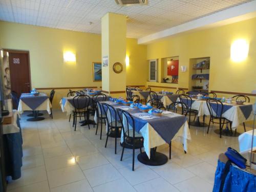 a room with tables and chairs with blue and white table cloth at Hotel Mary in La Spezia