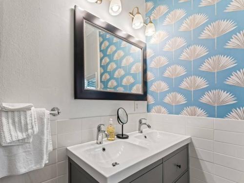 a bathroom with a sink and a mirror at Casa Lovett - Tropical Bungalow in Saint Augustine