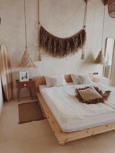 Un dormitorio con una gran cama de madera con sábanas blancas. en LISSA home en Vis