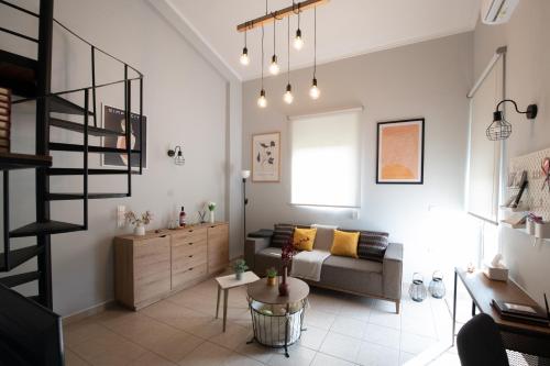 a living room with a couch and a staircase at Minimal loft at Kastellokampos in Patra