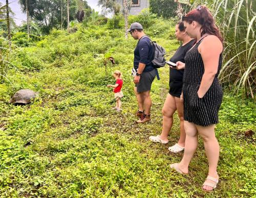 a group of people standing on a trail with a turtle at Natura Gardens Galápagos in Bellavista