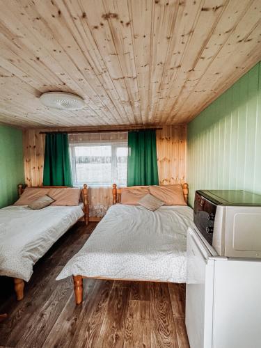 two beds in a room with green curtains at Käopesa Kodumajutus in Põlva