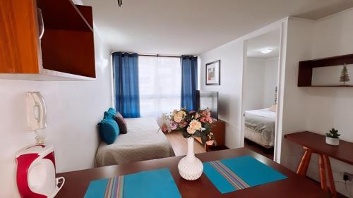 a small room with a table and a bedroom at Apartamentos Bulnes in Santiago