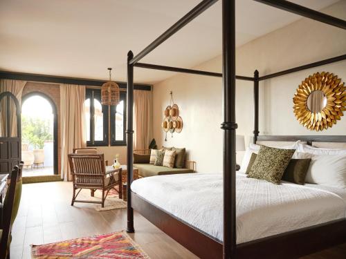 a bedroom with a canopy bed and a living room at Dar Jasmine in Chefchaouene