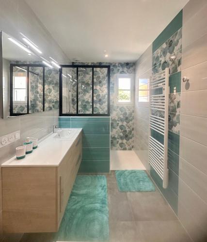 une salle de bain avec un lavabo et une douche dans l'établissement LA CASA DE BABOU, au Château-dʼOléron