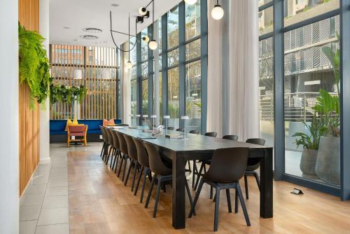 a dining room with a black table and chairs at Neighbourgood Newlands in Cape Town
