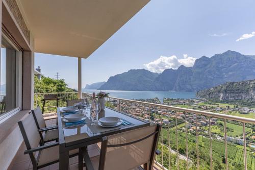 un tavolo e sedie su un balcone con vista sulle montagne di Villa Panorama with private pool - Happy Rentals a Torbole