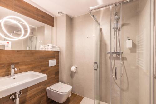 a bathroom with a shower and a toilet and a sink at Hotel Wisła Premium in Wisła