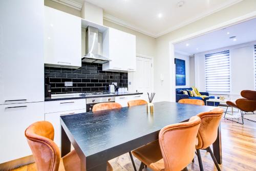 倫敦的住宿－Hybrid Resi - Battersea，厨房以及带桌椅的用餐室。