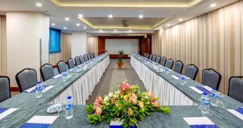 a long table in a room with chairs and flowers at Bera Konya Hotel in Konya