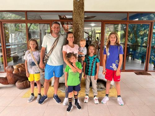 a family posing for a picture in front of a house at Natura Gardens Galápagos in Bellavista