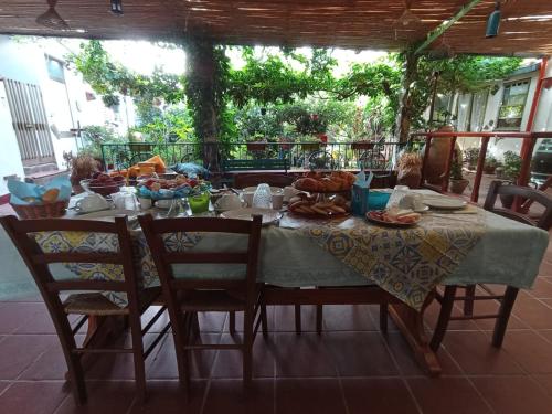 un tavolo con sopra del cibo e delle sedie intorno di Bed & Breakfast Paui a Càbras