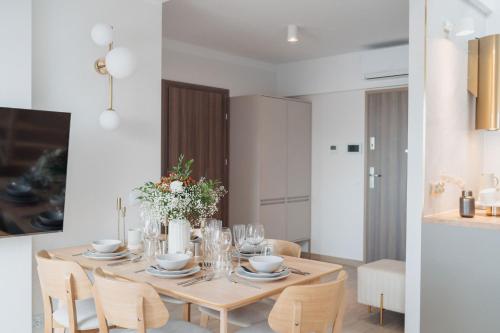 a dining room with a wooden table and chairs at Muse - LoftAffair Spa Collection in Kraków