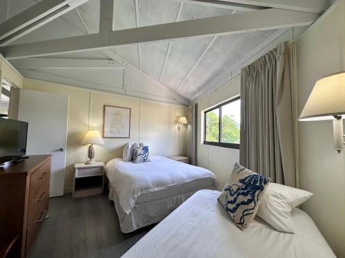 マラソンにあるCoco Plum Beach & Tennis Club & Marinaのベッド2台とテレビがあるホテルの部屋