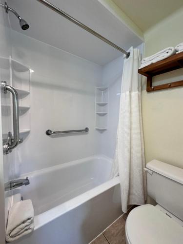 ein Badezimmer mit einer weißen Badewanne und einem WC in der Unterkunft Coco Plum Beach & Tennis Club & Marina in Marathon