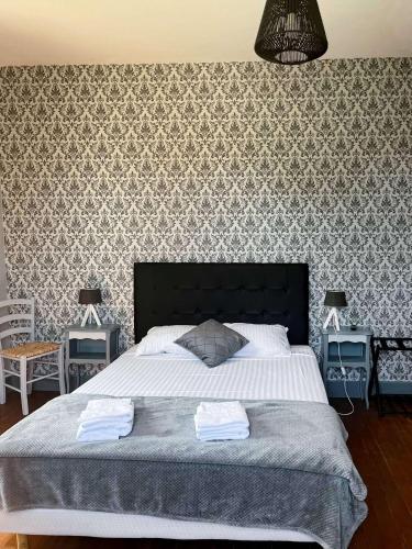 - une chambre avec un grand lit et un mur à motifs dans l'établissement The Rooms of Vilmorais - Red, à Arcomps