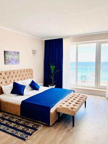 a bedroom with a large bed and a large window at KIR House On The Beach in Eforie Nord