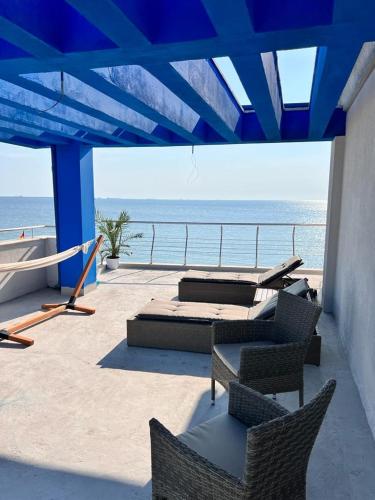 a patio with beds and chairs and the ocean at KIR House On The Beach in Eforie Nord