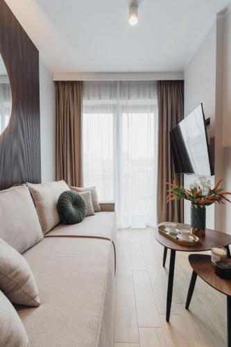 a living room with a couch and a table at Muse - LoftAffair Spa Collection in Kraków