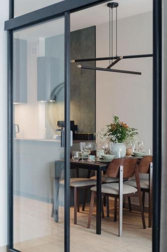 a dining room with a table and a glass door at Muse - LoftAffair Spa Collection in Kraków