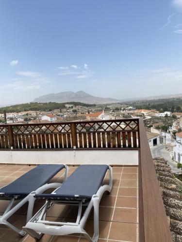 a balcony with two lounge chairs and a view of a city at Alhanda Apartahotel in Benamaurel