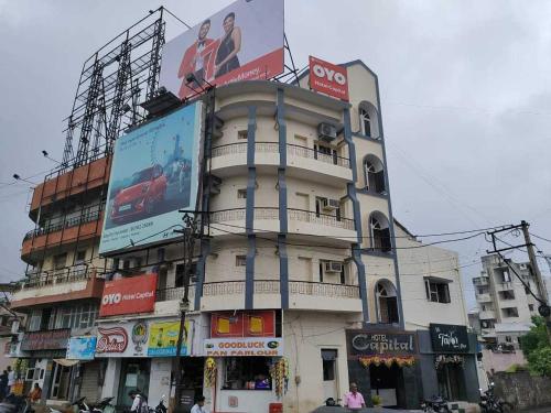 un edificio alto con una valla al costado. en OYO Flagship Hotel Capital, en Rajkot