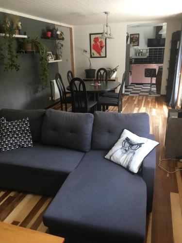 uma sala de estar com um sofá azul e uma sala de jantar em Maison entre mer et campagne em Landéda