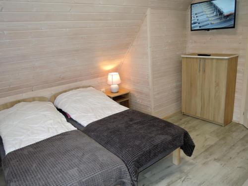 a bedroom with a bed and a table with a tv at New holiday homes for 7 people in Dziwnówek in Dziwnówek