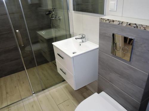 a bathroom with a white sink and a shower at Holiday Home in Dziwnówek by Sea and Lake in Dziwnówek