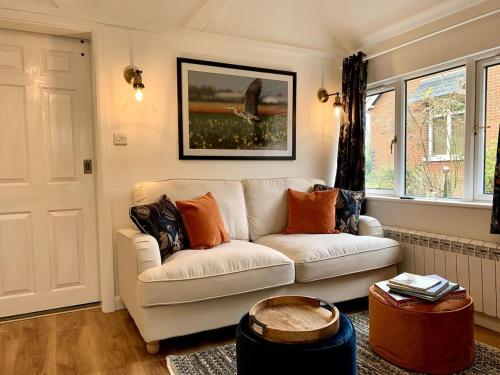 a living room with a white couch and a table at Delightful 1 bed, 1 bath Norfolk Broads Guesthouse in Halvergate