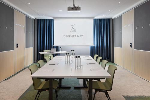 a conference room with a white table and chairs at Novotel Rennes Alma in Rennes