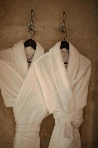 deux mannequins en robes blanches suspendues à des crochets dans l'établissement Hôtel particulier Fénelon - XIIIe, à Sarlat-la-Canéda