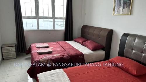 um quarto com 2 camas e uma janela em Ladang Tanjung Dar Assalam Homestay em Kuala Terengganu