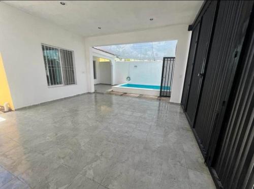 een lege woonkamer met een zwembad op de achtergrond bij Casa Liam in Mérida