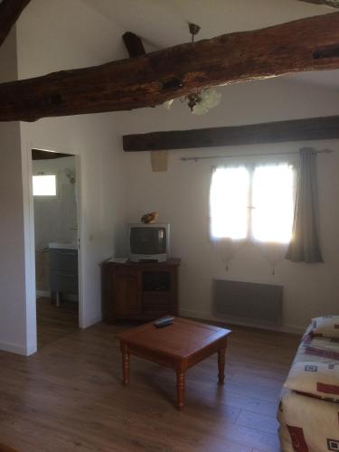 un salon avec une table et une télévision dans l'établissement Château Laborde Caudalie, à Saint-Médard-de-Guizières