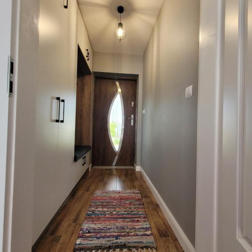 a hallway with a door and a rug at Green Hill House in Pępice